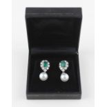 A pair of 18ct. white gold, emerald and diamond earrings with pearl drops, each set central