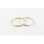 A pair of 18ct. gold Italian circular bangles, one in yellow gold, the other in rhodium plated white