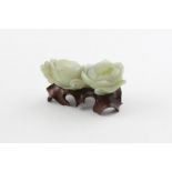 An early 20th Cent Chinese jade carving depicting two entwined Lotus flowers raised on wooden base