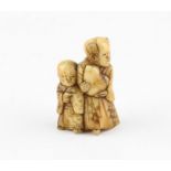 A Japanese Meiji netsuke of figures holding a gourd