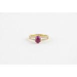 An 18ct. yellow gold, ruby and diamond dress ring, four claw set central oval cabochon ruby. the
