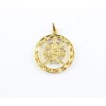 An Omani yellow metal circular pendant, the centre fashioned with the national emblem of a Khanjar