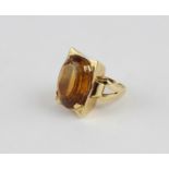An 18ct. yellow gold and topaz dress ring, the large rectangular mount with convex short sides,