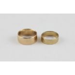 Two 9ct. yellow gold bands, the larger plain polished, the smaller decorated with two lozenge shaped