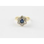 An 18ct. gold, sapphire and diamond cluster ring, the flower form mount set round cut sapphire