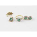 An 18ct. gold, emerald and diamond cluster ring, the white gold mount set round cut emerald to