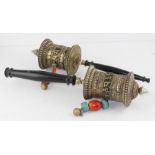 Two Tibetan brass and silvered prayer wheels, with inscription bands and jewelled glass bead