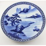 A 19th century oriental Kangxi style large blue and white charger decorated centrally with a