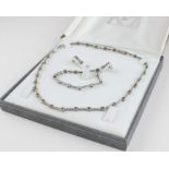 A 14ct. white gold, diamond and sapphire necklace, bracelet and earrings suite, the princess