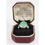 A 14ct. yellow gold and jade ring, set oval cabochon green jade within reverse tapered foliate