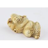 A late 19th century Chinese ivory Lohan, the recognisable figure in recumbent pose, 6.5 cm long
