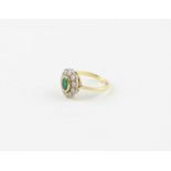 An 18ct. gold and diamond ring, the mount of ovoid form with lobed rim, set central oval cut emerald
