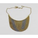 An 18ct two tone gold choker fringe necklace, having solid yellow gold arc suspending loops of