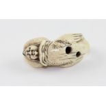 A Japanese Meiji Period (1868-1912) carved marine ivory 'fertility' netsuke, modelled as a fish like