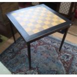A mid 20th Century chequer topped games table, raised on folding legs,