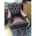 Two contemporary brown leather armchairs,one button backed, together with two brown leather pouffes.