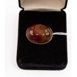 A 19th Century polished banded agate brooch, set within a rope border of unmarked yellow metal,