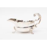 A George V sterling silver sauce boat, London 1922, in George II style, with three pad feet,