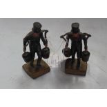 Two Hummel lead cast figures in 19th Century dress each carrying fire buckets on a yoke named on