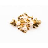 A yellow metal brooch set with four cultured pearls