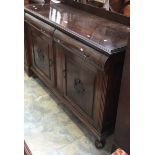 An early 20th Century dark oak sideboard with twom drawers and two cupboards.