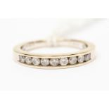 A diamond half set eternity ring, nine brilliant cut diamonds channel set in 18ct white gold,