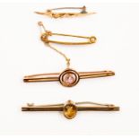 A collection of four 9ct gold brooches to include a rose gold target style brooch with pink