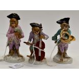 After Meissen; three monkey band figures, 19th Century painted,