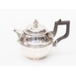 An early 20th Century white metal teapot, possibly American, having an ebony handle, 277 grams / 8.