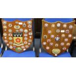 A collection of British & World Fire Brigade cap badges mounted on two wooden shields one with