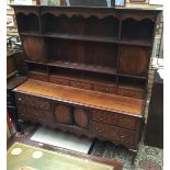 A George III oak dresser with rack, the base with four drawers and two doors between,
