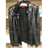 A black sequin Lucien Lelong jacket, with a peplum detail, late 1930's or early 1940's.