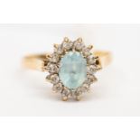 A cluster set dress ring, set with a blue oval topaz with paste set border, 9ct gold, size R,