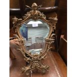 A Rococo style 19th Century gilded mirror possible French with angel finial,