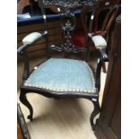 A dark mahogany armchair with carved foliate splat and top,