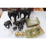 Collection of carved ebony elephants along with onyx cigarette box, ashtray,