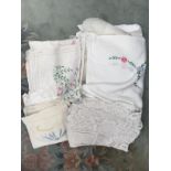 A collection of assorted linen, to include; embroidered tablecloths, lace clothes,
