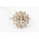 A platinum and diamond cluster ring, tired cluster set in unmarked white metal probably 9ct gold,