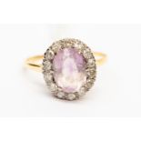 A diamond and amethyst dress ring, the central oval stone measuring approx 11mm x 8mm,