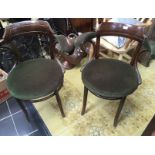 Two mid 20th century elbow chairs with splayed legs.