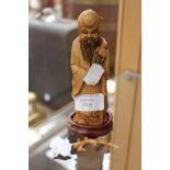 An ivory carving of an old man diety, signed to base,