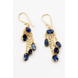 A pair of sapphire pendant earrings comprising fire oval faceted sapphires suspended by 14 ct gold