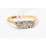A three stone diamond ring, illusion set in platinum and 18ct gold, size L,