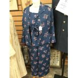 A silk teal ladies three piece suit with a floral design on the pattern;