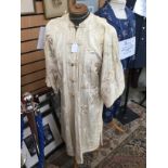 A cream Chinese style Edwardian coat, 1917/18, with Mandarin collar and frog fastenings,