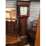 Early 20th century long case clock with mahoganey veneer and carved design door.