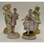 Four early 20th Century German figures of children and lady and gent