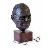 A contemporary bronzed resin head of a man with spectacles on a wood base. (Spectacles broken).