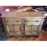 A 1960's Ercol Carved Elm Sideboard (High Wycombe, Buckinghamshire), fitted with two drawers over