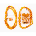 A collection of butterscotch amber jewellery comprising two graduated oval bead necklaces,